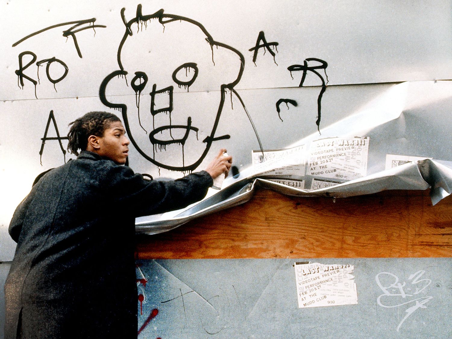 Jean-Michel Basquiat caught in the act of spray painting in the streets of New York for the film Downtown 81 produced between 1980-81 but only broadcast in 2001 (image taken from the film).